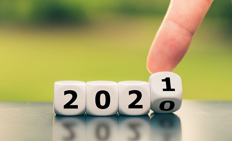 Hand turns a dice and changes the year 2020 to 2021